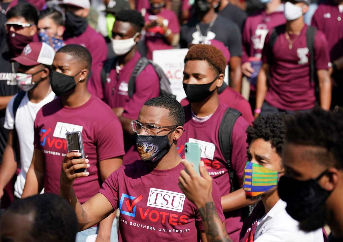 People listen to Mayor Sylvester Turner speak during the march to the polls event to kick off early voting at Texas Southern University Tuesday, Oct. 13, 2020 in Houston. The mayor has issued a voting challenge among TSU, Rice and the University of Houston.