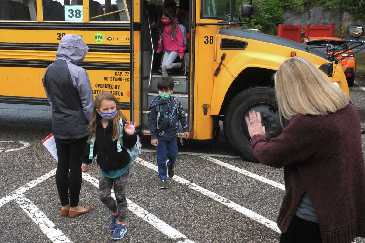 Principal Amy Yost, right, greets students as they arrive at Sunnyside Elementary School in Shelton on Tuesday.