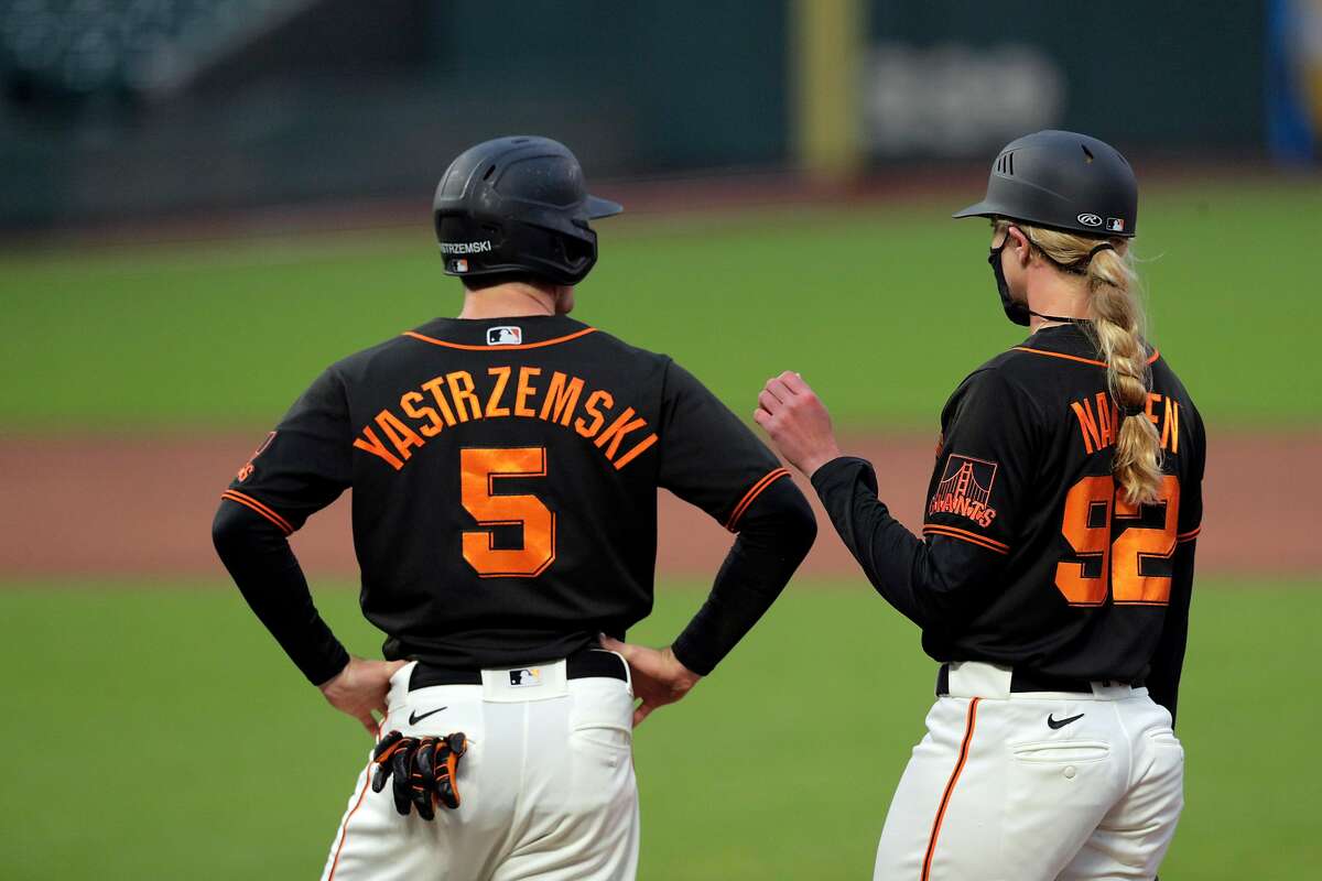 Giants first base coach Alyssa Nakken, right, chats with Mike Yastrzemski (5) in the third inning after he walked as the San Francisco Giants played the Oakland Athletics in a summer exhibition game at Oracle Park in San Francisco, Calif., on Tuesday, July 21, 2020.