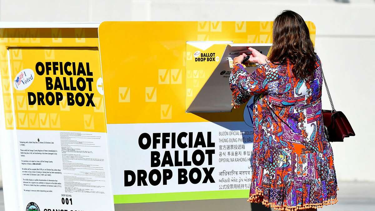 A woman casts her ballot at an official Orange County drop box in Santa Ana this week. The Republican Party said it would defy a cease-and-desist order to remove unauthorized ballot boxes in three counties.
