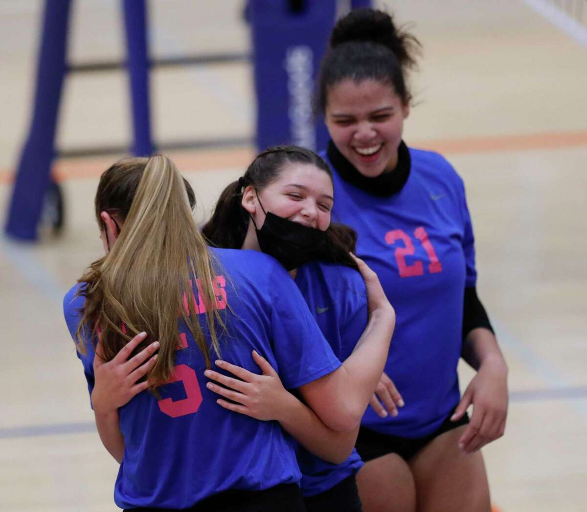 Grand Oaks right side hitter Emma Soniat (17) gets a hug from middle blocker Kamie Lohnes (5) after a block as outside hitter Fallon Thompson (21) looks on during the third set of a District 13-6A high school volleyball match at Grand Oaks High School, Tuesday, Oct. 13, 2020, in Spring. Grand Oaks swept College Park in straight sets.