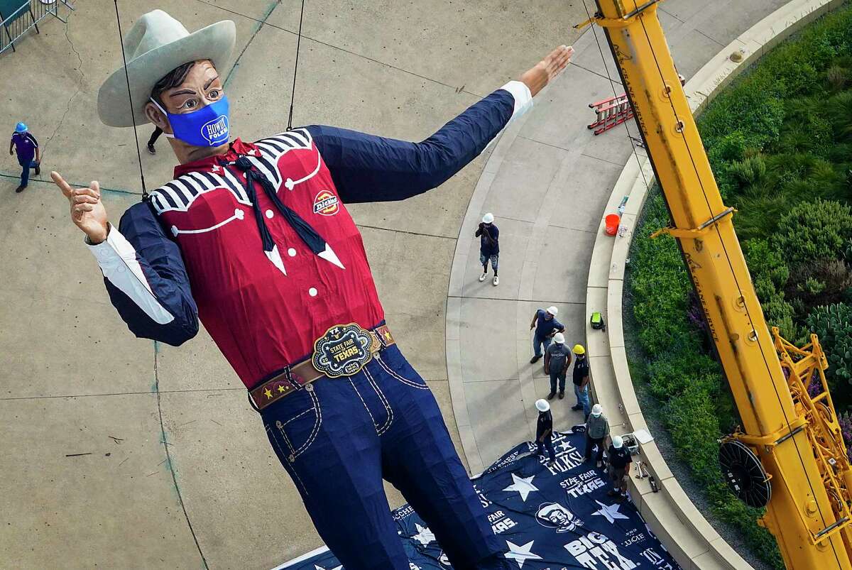 Workers install Big Tex in Fair Park on on Wednesday, Sept. 16, 2020, in Dallas. The State Fair isn't happening this year, but Big Tex will still be there, wearing a mask that is 84 inches by 45 inches, or approximately 7 feet by 4 feet. (Smiley N. Pool/The Dallas Morning News)