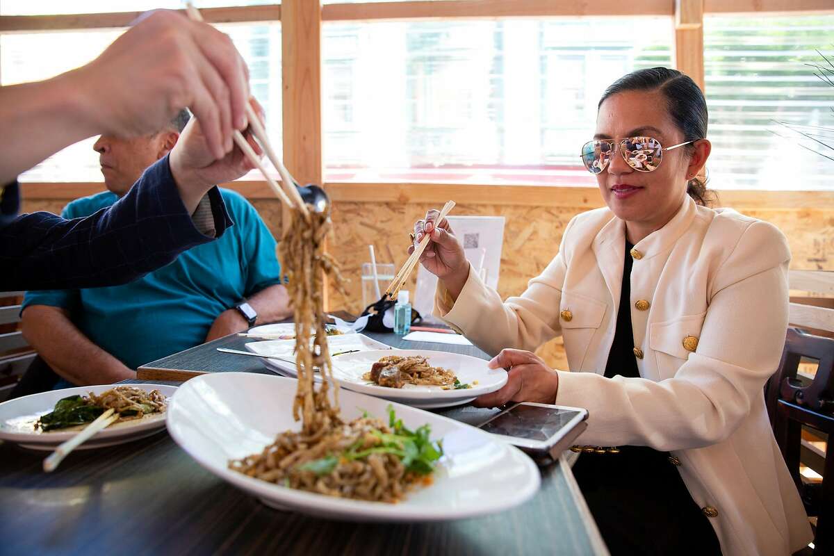 Calvin Lam serves up an order of house noodles to Hilga Africa at House of Nanking restaurant in San Francisco.