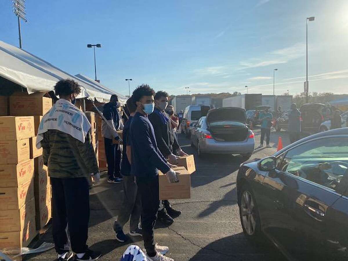 UConn men’s basketball players help distribute groceries at a Foodshare-sponsored food drive on Thursday morning at Rentschler Field.