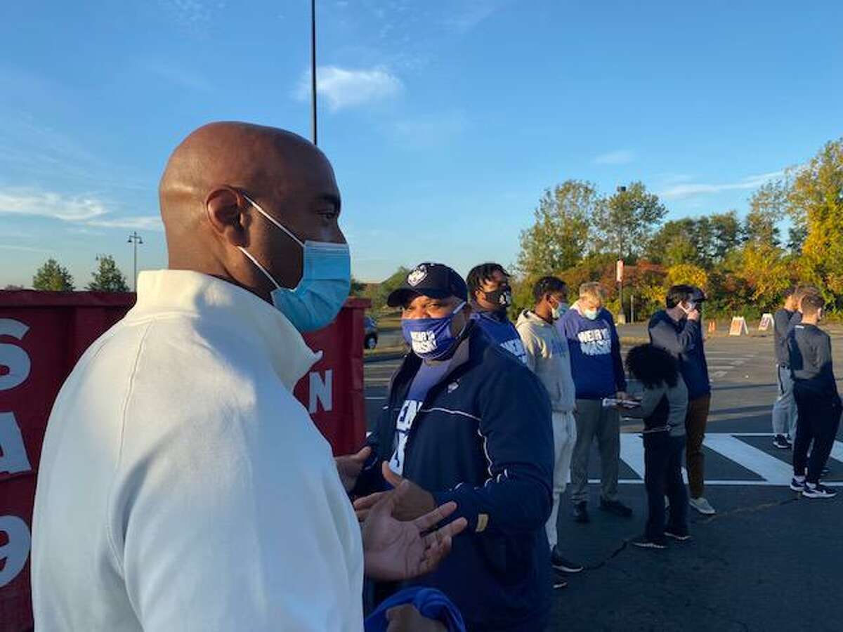 Former UConn stars Chris Smith and Scott Burrell urged people to wear a mask while also handing out groceries at a food drive on Thursday morning at Rentschler Field.