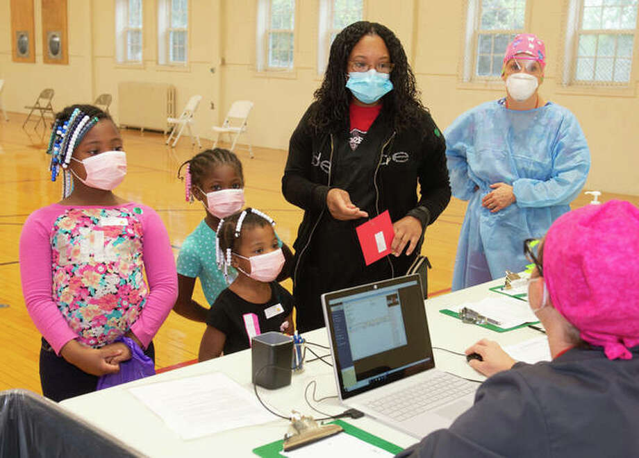 Checking in at the Southern Illinois University School of Dental Medicine’s 15th annual Give Kids a Smile Day are, from left, Tarjayee, Tarmajae and Taliyiah Turner along with their mother, Tarshaee Turner. This year’s event saw 110 children and provided $52,990 in dental services for free.