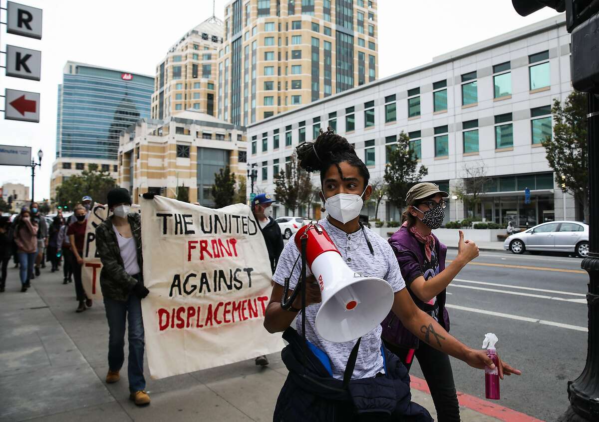 Dayton Andrews, with The United Front Against Displacement, leads a group of demonstrators along 14th St. during a protest against the City of Oakland's proposed encampment management policy in Oakland, Calif., on Saturday, October 10, 2020.