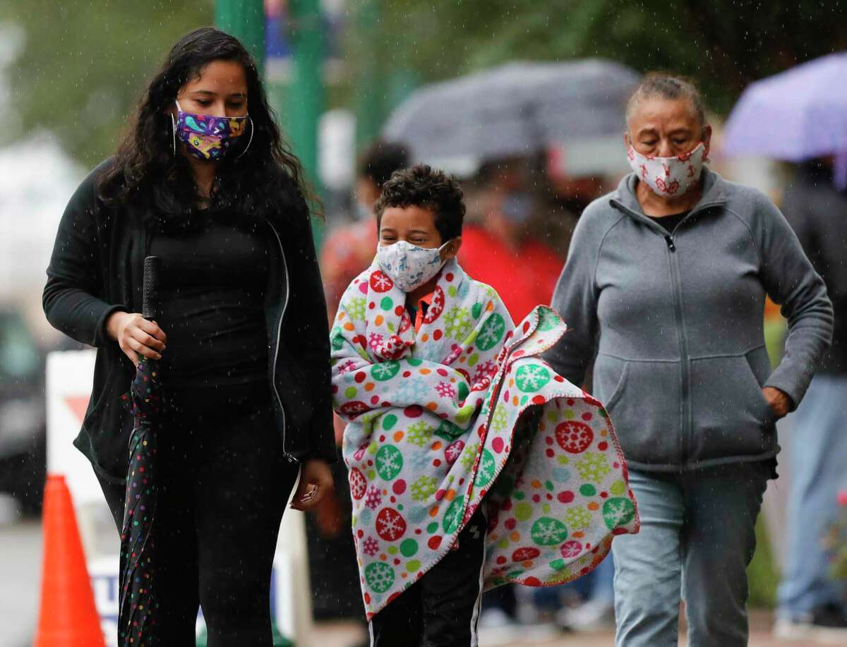 Angelo Zirrilla, center, wraps himself in a blanket in 50 dregree, rainy weather after watching his mother, Jessica Camo, and grandmother, Dina Garcia, vote at the Lee G. Alworth Building, Friday, Oct. 16, 2020, in Conroe. Camo said she’s taken her son to watch her vote since he was five. “I take him with me every time just so he gets to see the process,” she said. “I think it’s important.” A cool front moved through Montgomery County Friday, leaving showers in its wake and temperatures in the 50s. Saturday’s forecast calls for another cool morning in the 50s. Sunday calls for more humidity with a mix of sun and clouds and highs into the 80s.