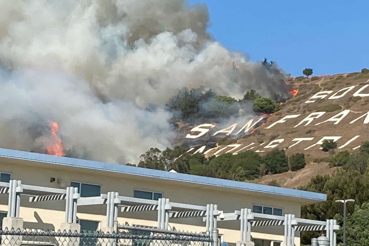 Firefighters are battling a four-alarm grass fire Friday afternoon on San Bruno Mountain in South San Francisco.