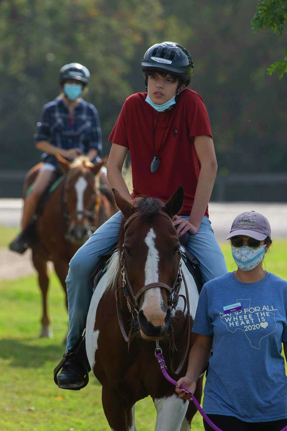 Paul Perez rides horses with his mother, Suzanne Garofalo, at Camp For All, Saturday, Oct. 10, 2020, in Burton, TX.