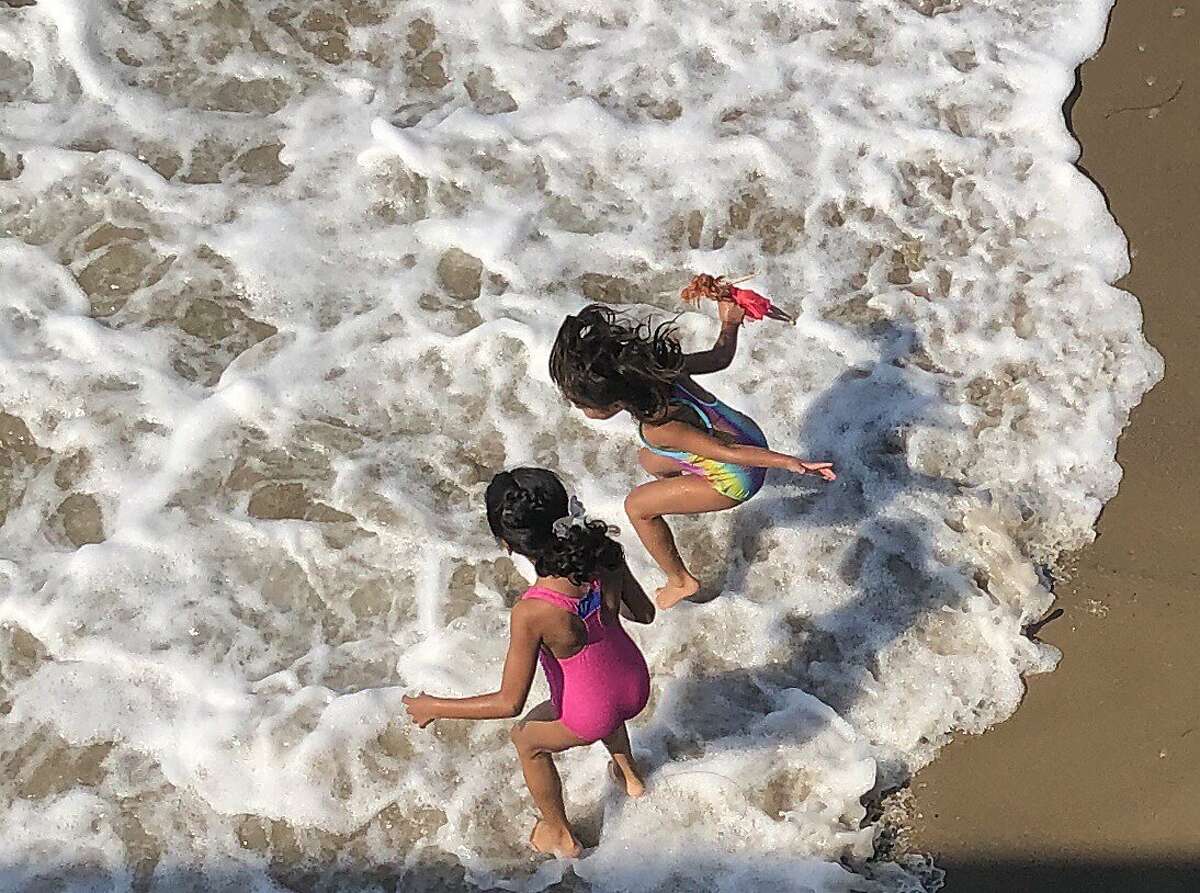 Kids in surf and pier and boardwalk Ventura state beach