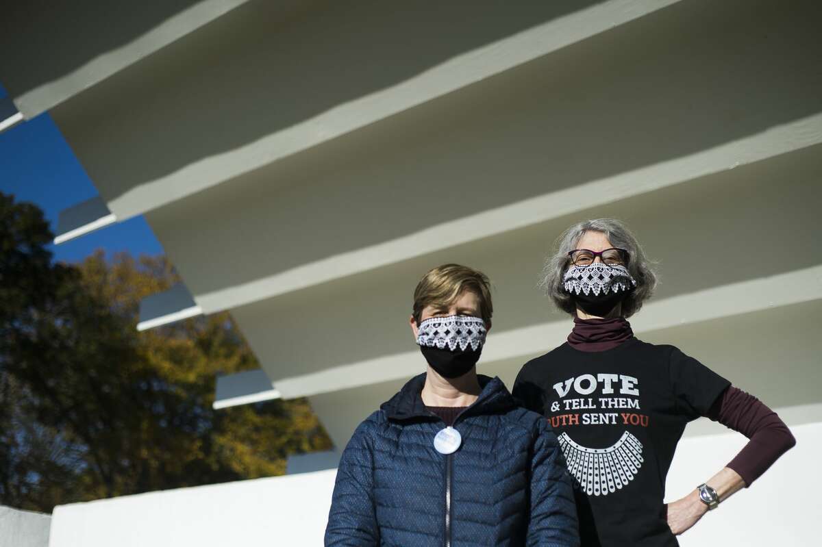 Jennifer Austin, left, and Allison Wilcox, right, pose for a portrait as dozens of people gather for a Rally for Democracy hosted by Women of Michigan Action Network (WOMAN), in coordination with a march on Washington and sister actions in cities and communities across the country, Saturday morning, Oct. 17, 2020 at Central Park in Midland. (Katy Kildee/kkildee@mdn.net)