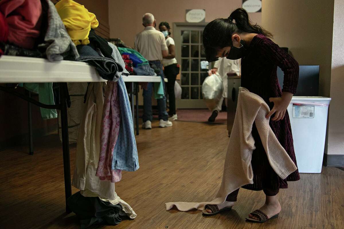 Somaleya Bashar Doost, 4, a refugee from Afghanistan, looks through clothing during the Center for Refugee Services winter coat distribution .