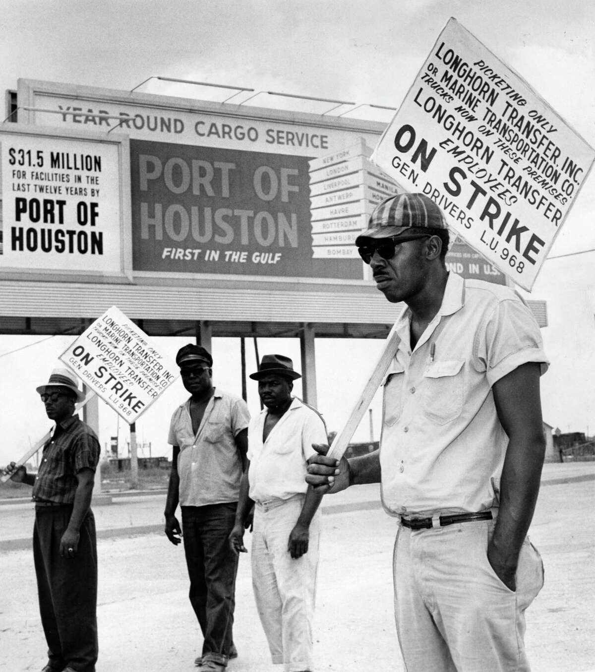 Teamster pickets who halted longshoremen again in port. From left, T.R. Fleming, C. Williams, Andrew Harris, and Dan Shannon walk the picket line during a longshoremen strike at the Port of Houston in 1963.