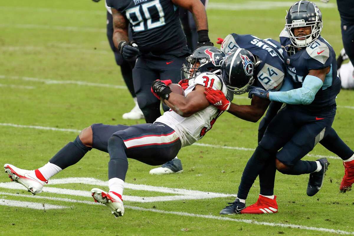 Houston Texans running back David Johnson (31) is stopped by Tennessee Titans inside linebacker Rashaan Evans (54) and cornerback Malcolm Butler (21) during the fourth quarter of an NFL football game at Nissan Stadium on Sunday, Oct. 18, 2020, in Nashville.