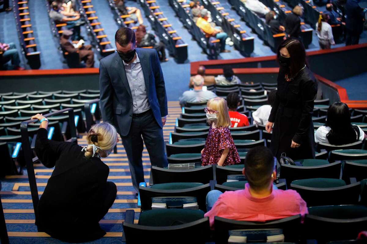 Masked church go-ers greet each other during Lakewood Church’s first day of reopening for in-person services on Sunday after being closed since March on Sunday, Oct. 18, 2020.