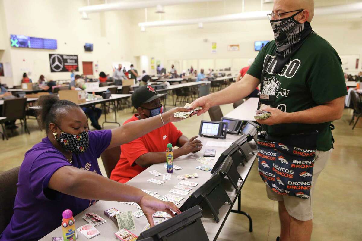 Jason Franklin sells dollar card games to Ruby Jackson, 33, left, and Kim Lewis, 44, at Northeast Bingo, Wednesday, Oct. 14, 2020. Bingo halls throughout San Antonio have had to adjust to the threat from the coronavirus.