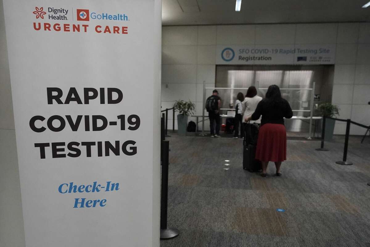 People wait in line to register at the SFO COVID-19 rapid testing site at San Francisco International Airport in San Francisco, Thursday, Oct. 15, 2020.