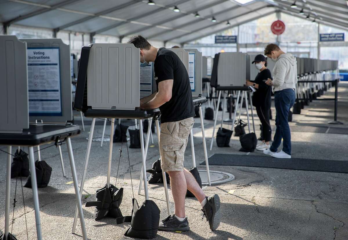 People are seen at an outdoor voting center in San Francisco on Oct. 5, 2020. The city set up an outdoor voting center outside City Hall to provide service for voters during the COVID-19 pandemic.