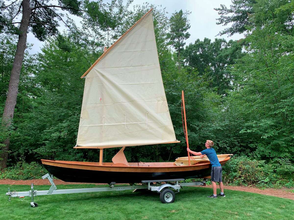 Jacob Hyde of Midland makes an adjustment to his finished sailboat. (Photo provided)