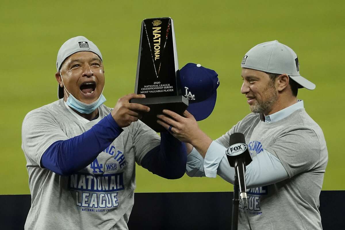 Los Angeles Dodgers manager Dave Roberts, left, and President of Baseball Operations Andrew Friedman celebrate with the trophy after winning Game 7 of a baseball National League Championship Series against the Atlanta Braves Sunday, Oct. 18, 2020, in Arlington, Texas.