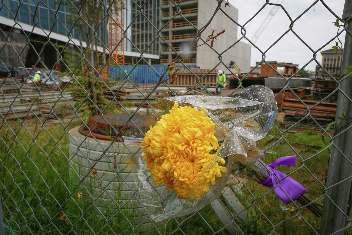 A small bouquet of flowers in the fence at the sight of a deadly construction collapse inside the future headquarters of Marathon Oil Corporation Thursday, Oct. 8, 2020, in Houston.
