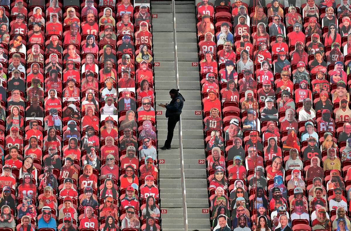 A security guard fills out paperwork amid fan cutouts behind the end zone in the second half as the San Francisco 49ers played the Arizona Cardinals at Levi’s Stadium in Santa Clara, Calif., on Sunday, September 13, 2020.