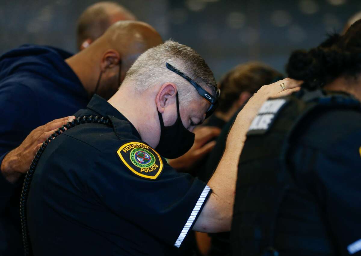 Houston Police officers embrace for a moment of prayer after learning Sgt. Harold Preston died at Memorial Hermann Hospital on Tuesday, Oct. 20, 2020, in Houston. Two officers were shot by a suspect during a domestic violence call at an apartment complex near El Rio and Holly Hall streets.