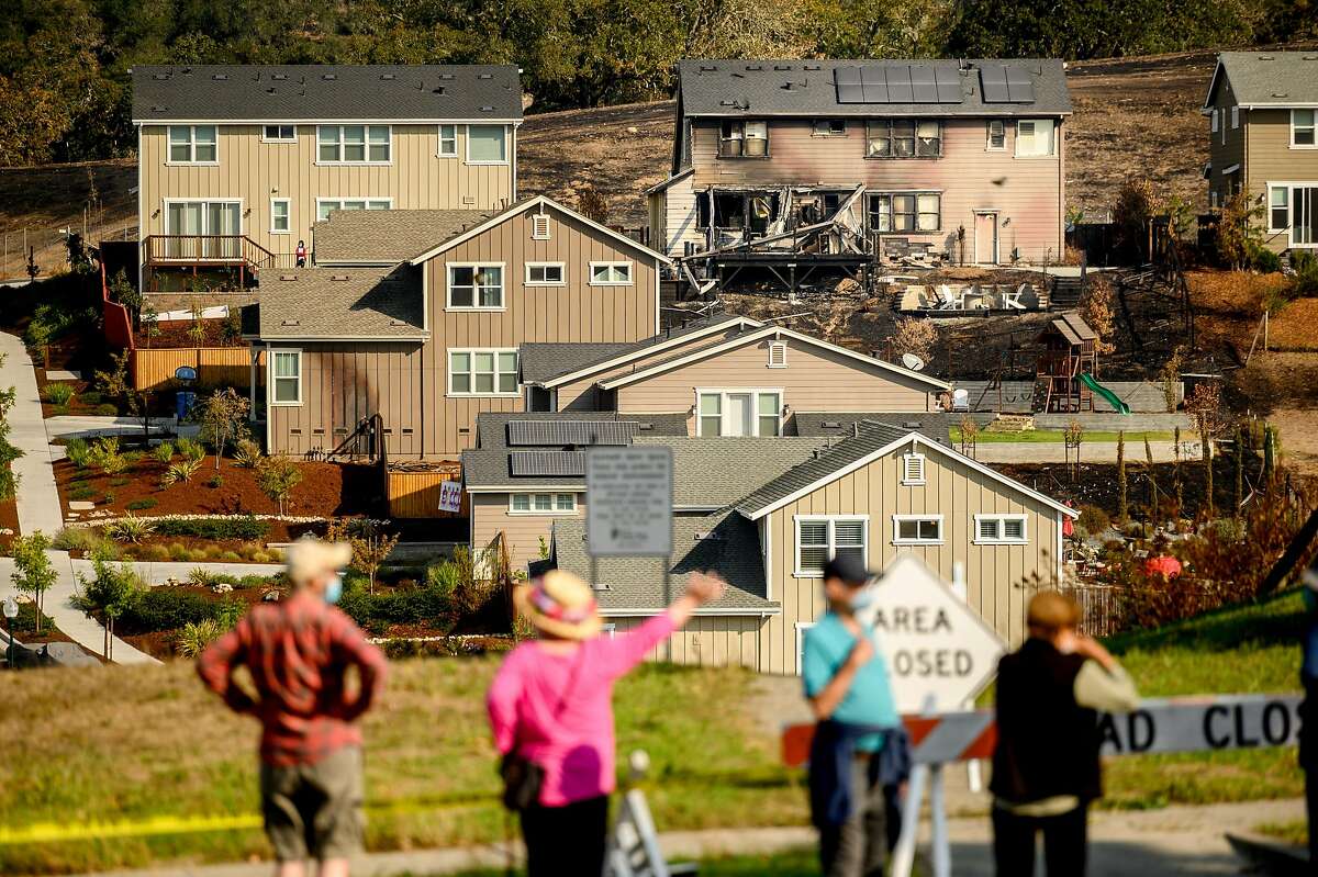 Following the Glass Fire, Skyhawk neighborhood residents stop to examine burned homes on Tuesday, Oct. 6, 2020, in Santa Rosa, Calif.