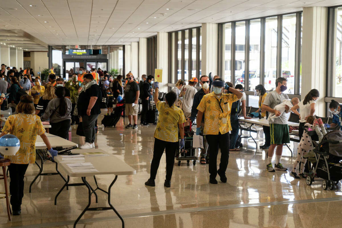 State officials check to be sure all arriving visitors and residents have answered a health questionnaire, had their temperatures taken and shown proof of a negative COVID-19 test at Honolulu International Airport.