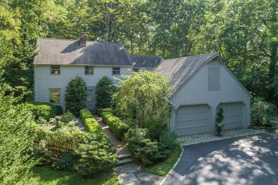 The gray colonial house at 9 Little Fox Lane in Lower Weston sits on a 2.03-acre level, sloping, wooded and attractively landscaped property. Photo: Contributed Photo /