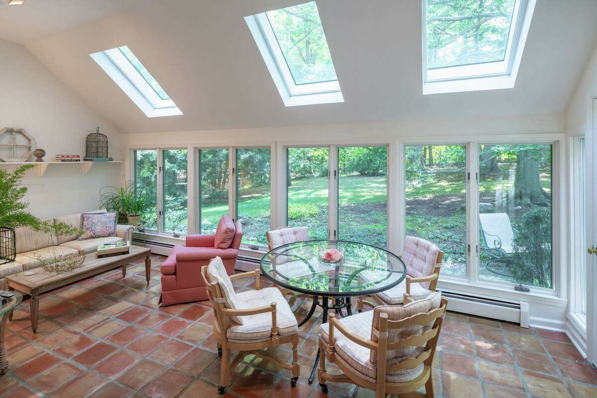 The sizable sun room features a ceramic tile floor, wall of windows, skylights, and a door to the grounds. There is much charm to this 2,663-square-foot house with