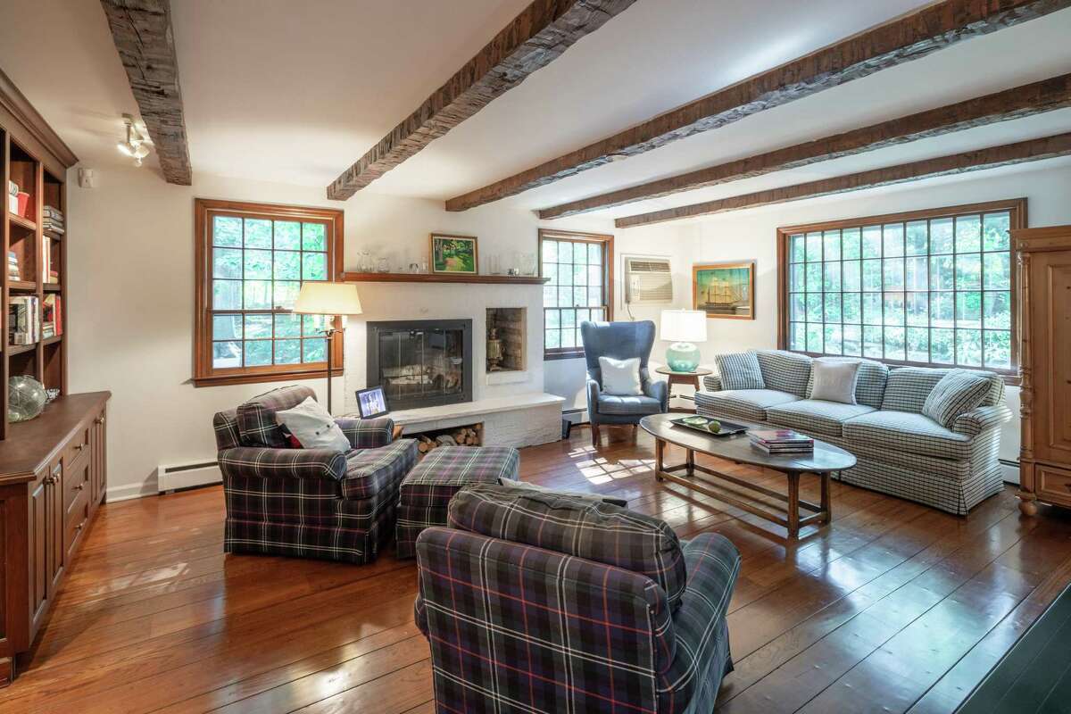 In the spacious family room there are exposed beams, a fireplace with wood storage, and built-in cabinetry and shelving. In the sizable kitchen there is a two-tiered, L-shaped peninsular counter; ceramic tile floor, breakfast room, high-end appliances, skylights and a door to the backyard.
