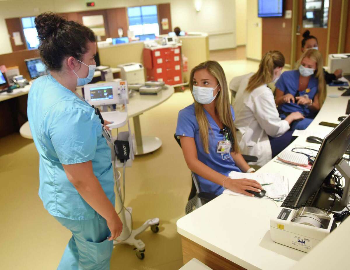 Clinical Assistant Maggie Buckly, left, and Analese Carlucci, RN, second from left, work at the former COVID-treatment center on the eighth floor at Stamford Hospital on July 21. More than 200 people are hospitalized with the coronavirus, up from 110 just a few weeks ago.