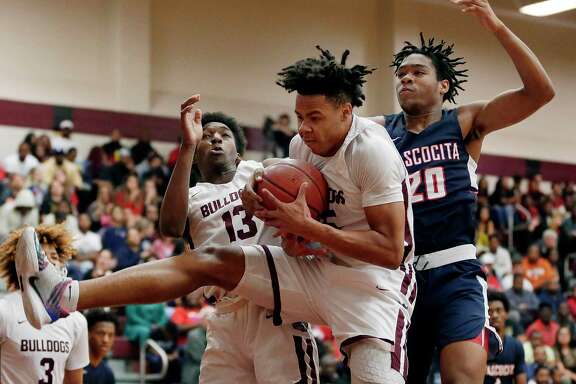Summer Creek Jarek Thomas, middle, pulls down a rebound in front of guard Steven Sawyer (13) and Atascocita forward Landen King (20) during the first half of a high school basketball game Tuesday, Feb. 4, 2020 in Houston, TX.