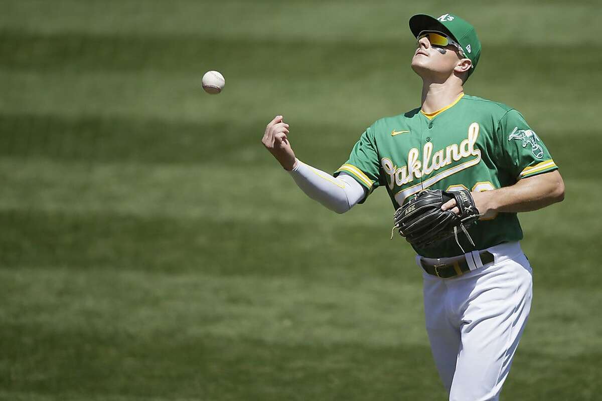 Oakland Athletics third baseman Matt Chapman (26) throws the ball into the empty stands after the end of the second inning in an MLB game against the Houston Astros at RingCentral Coliseum on Saturday, Aug. 8, 2020, in Oakland, Calif.