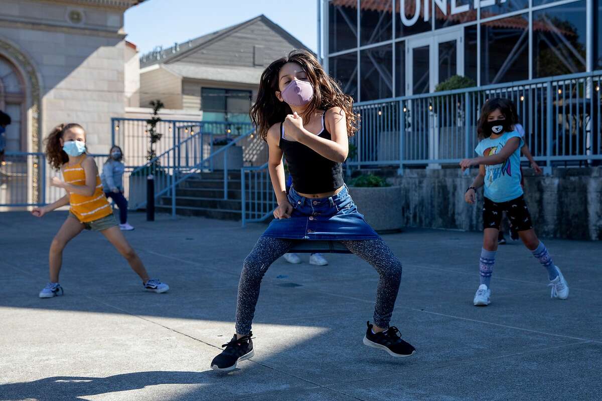 Students wear masks while participating in an activity with their dance pod organized by Dance Mission Theater in the Mission District of San Francisco, Calif. Tuesday, October 13, 2020. Several arts pods have popped up in San Francisco, funded by foundations for low-income kids since COVID-19 pandemic has shut down regular in-person schooling.