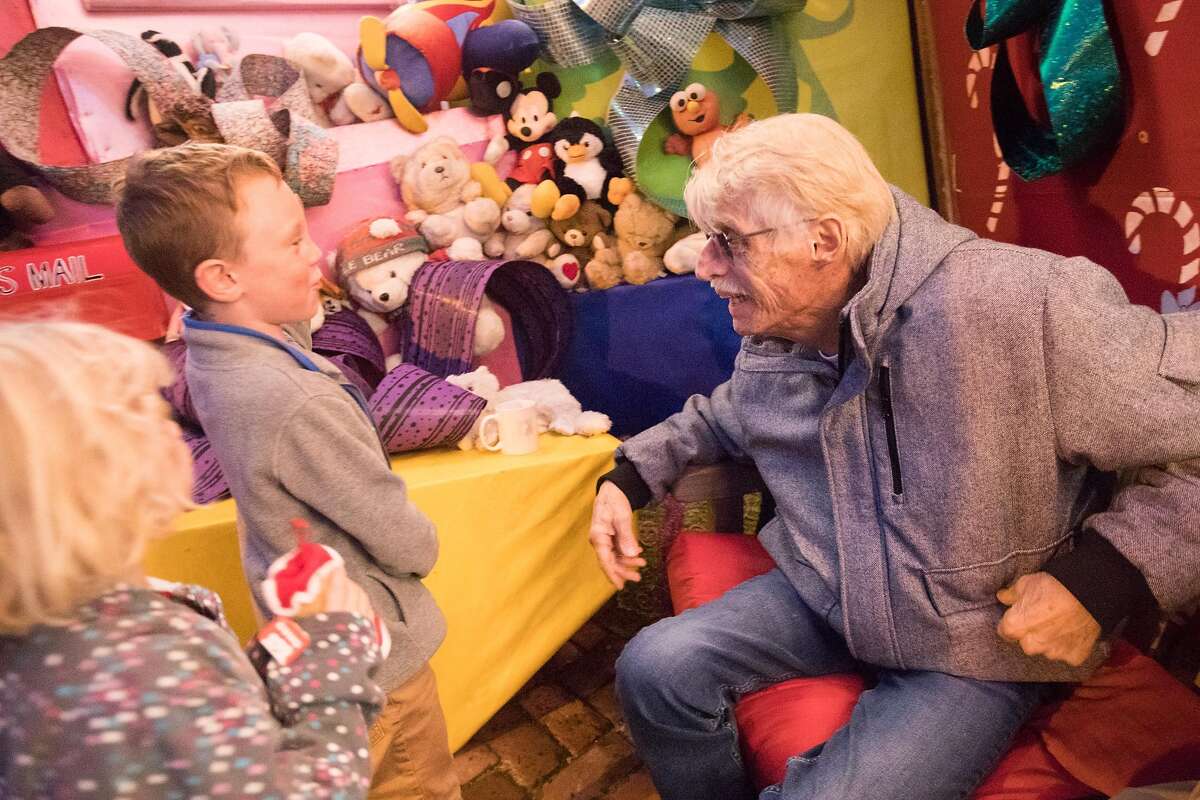 Tom Taylor speaks with a child outside his holiday-decorated house in San Francisco on Dec. 15, 2019.