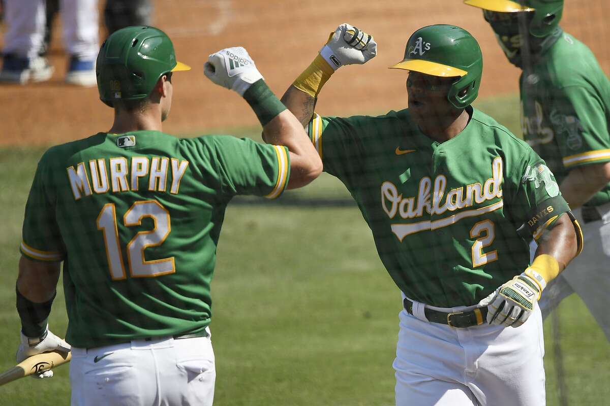 LOS ANGELES, CALIFORNIA - OCTOBER 06: Khris Davis #2 of the Oakland Athletics celebrates a solo home run against the Houston Astros with teammate Sean Murphy #12 during the second inning in Game Two of the American League Division Series at Dodger Stadium on October 06, 2020 in Los Angeles, California. (Photo by Kevork Djansezian/Getty Images)