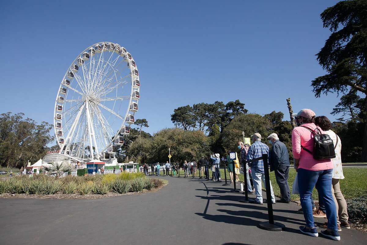 Ticket holders line up for a ride on the SkyStar Observation Wheel on the opening day to the public at the Golden Gate Park Music Concourse in San Francisco, California on October 21, 2020.