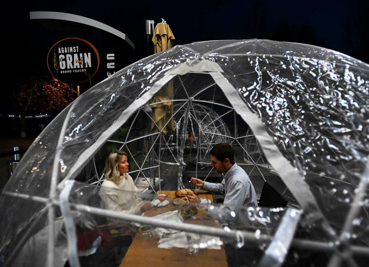 FILE -- People enjoy outdoor dining in a weather proof dome pod at Against the Grain Urban Tavern during the COVID-19 pandemic in Toronto on Wednesday, Oct. 21, 2020. (Nathan Denette/The Canadian Press via AP)