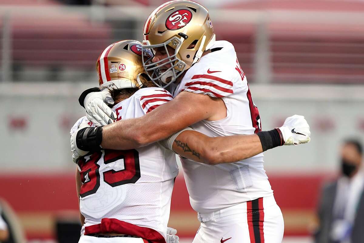 Mike McGlinchey, right, gives 49ers’ teammate George Kittle a hug after Kittle’s second-quarter touchdown against the Los Angeles Rams on Sunday night.