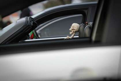 "Spooky" waits for his driver Grant Petty as drivers gather for a car meet in a parking lot along Northwest Freeway Saturday, Oct. 10, 2020, in Houston.