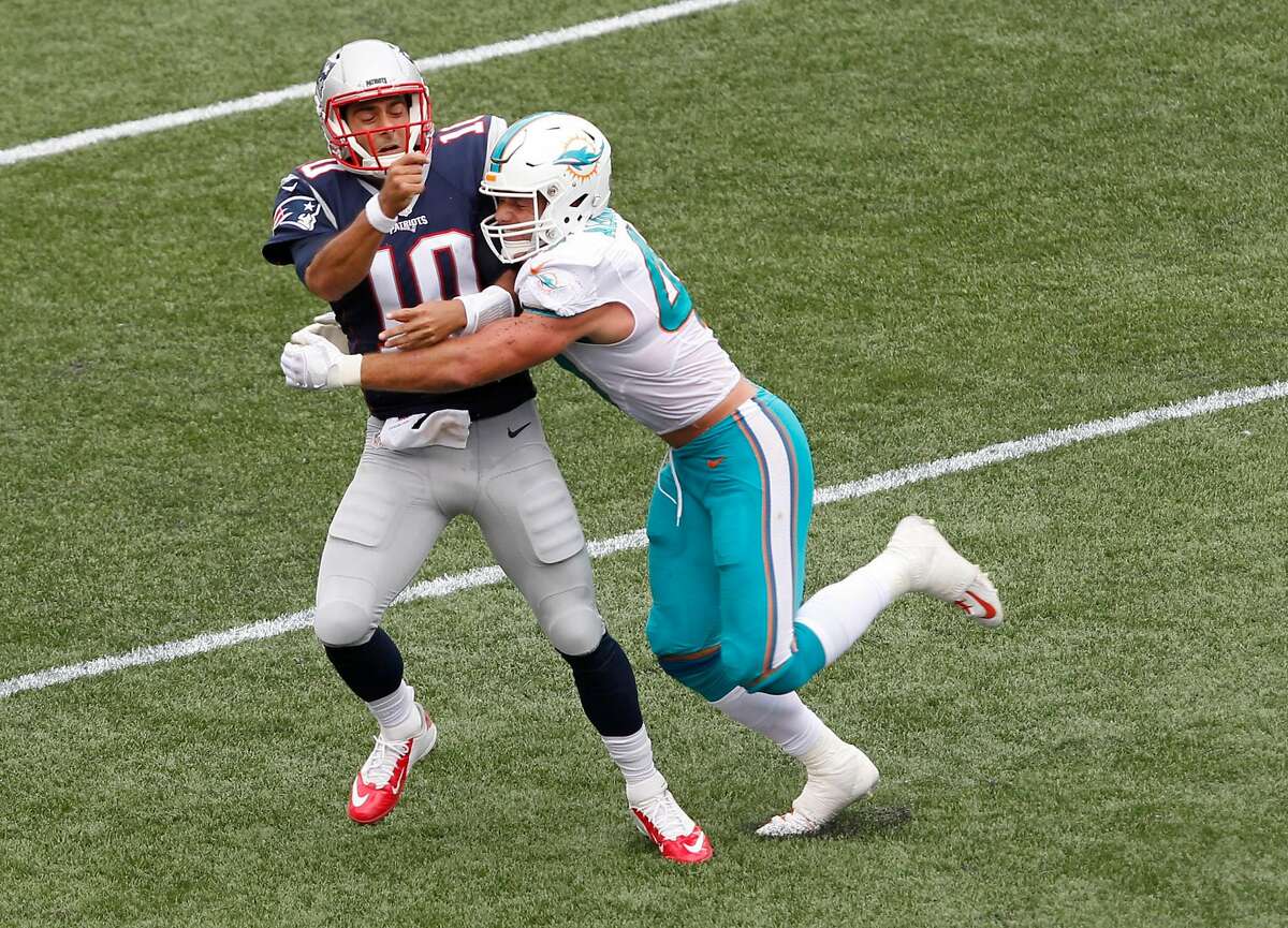 Miami Dolphins linebacker Kiko Alonso, right, hits New England Patriots quarterback Jimmy Garoppolo (10) after he threw a pass during the first half of an NFL football game Sunday, Sept. 18, 2016, in Foxborough, Mass. Garoppolo was injured on the play and did not return to the game. (AP Photo/Stew Milne)