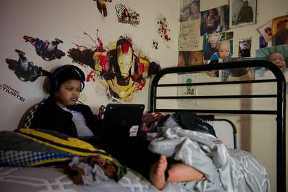Royal Holyfield, a fourth-grader at Tenderloin Community School, spends time in his room in San Francisco, Calif., on Oct. 21, 2020.
