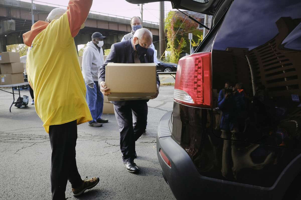 Congressman Paul Tonko loads a food box into a car as he helped out with other volunteers during a food distribution event put on by Catholic Charities of the Diocese of Albany and the Regional Food Bank of Northeastern New York on Wednesday, Oct. 21, 2020, in Albany, N.Y. (Paul Buckowski/Times Union)