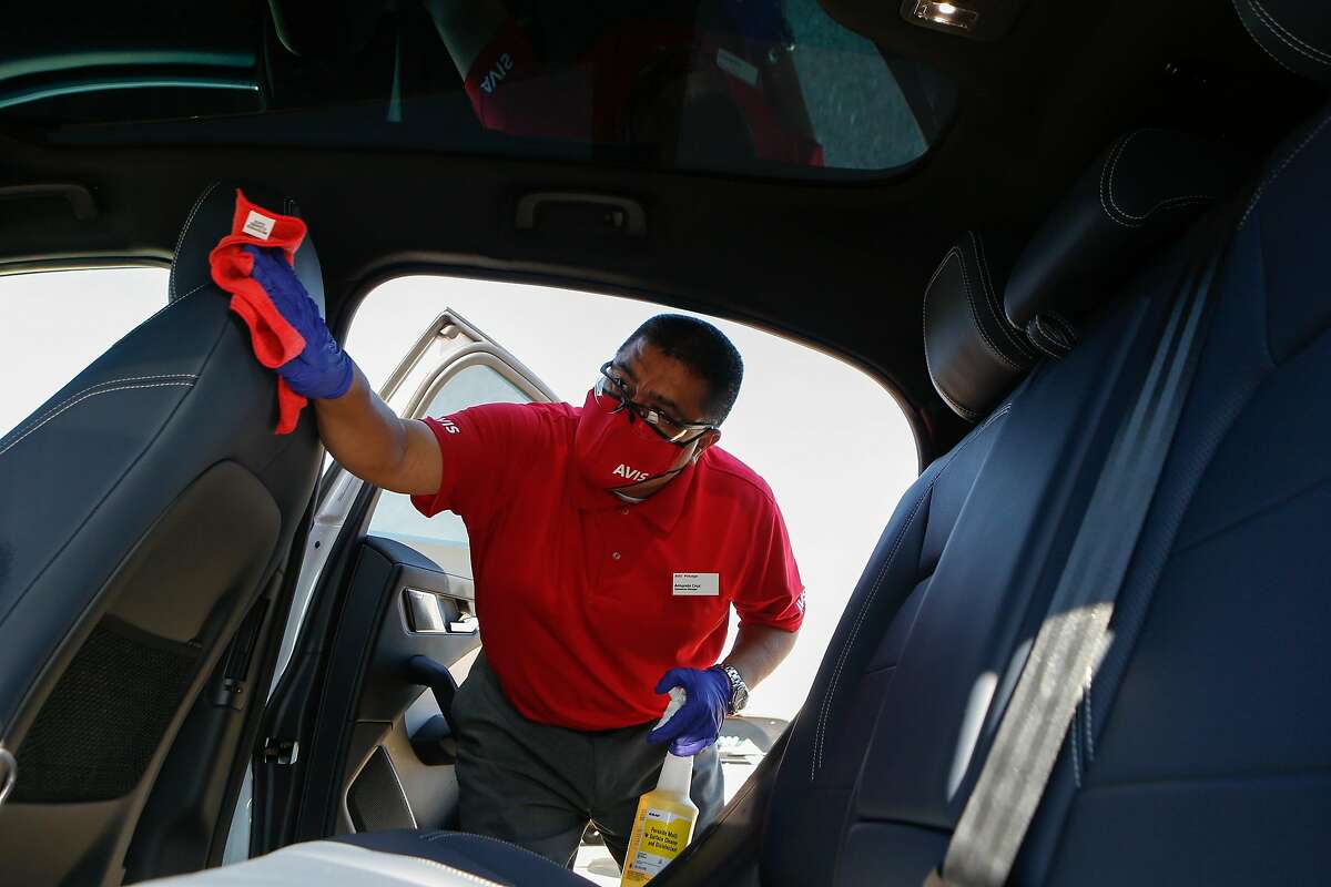 Armando Cruz sanitizes the inside of a Jaguar I-Pace after its test drive at Waymo's temporary location on Tuesday, October 20, 2020 in South San Francisco, Calif. Waymo is ramping up testing of its autonomous cars while including extra sanitizing precautions after each test drive at its temporary base.