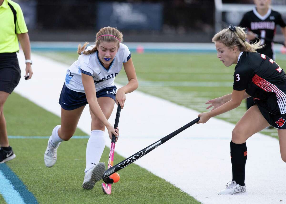 Tishy Cacciapaglia, right, looks to take the ball away from a Wilton player during a recent field hockey game.