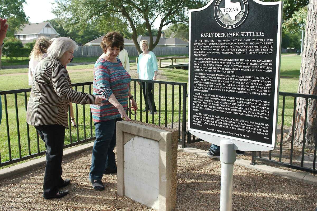 Deer Park Historical Committee members Janet Horsch and Pat Adams view the headstone and historical marker set in memory of early Deer Park residents Mary W. Jackson and William Wilson during a dedication ceremony Tuesday at Dow Park.