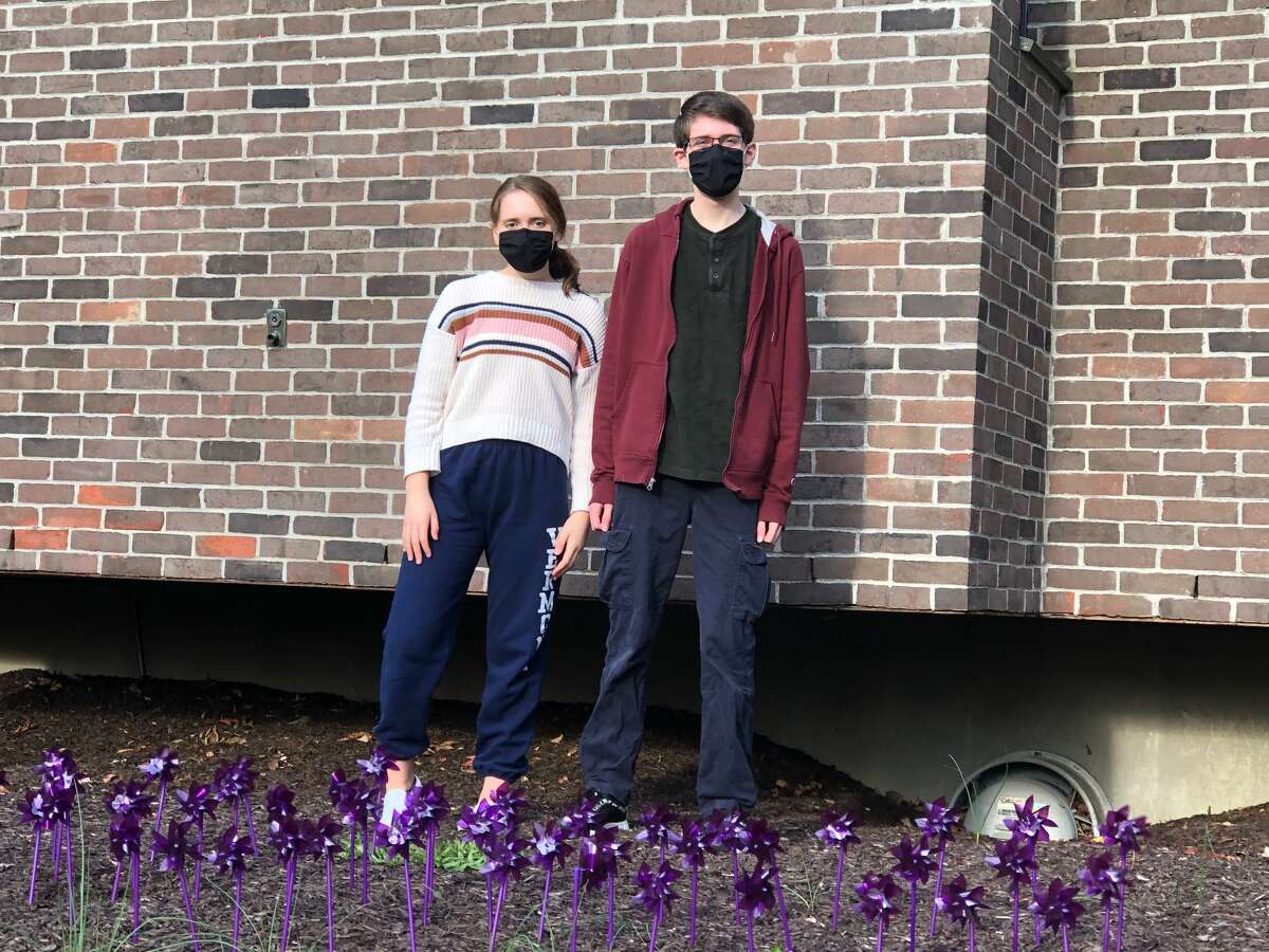 Wilton High School Teen PeaceWorks members Jeanette Rosenthal and Justin Rosenthal, participated in placing 77 purple pinwheels in front of Wilton police headquarters.